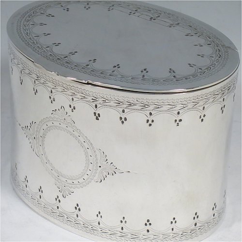 An Antique Victorian Silver Plated tea caddy box, having an oval straight-sided body, a flat lid with a hidden hinge, with hand-engraved bands of floral decoration top and bottom, together with two round  cartouches front and back, and sitting on a flat base. Made by the Mappin Brothers in ca. 1870. The dimensions of this fine hand-made antique silver-plated tea caddy box are height 9 cms (3.5 inches), length 12 cms (4.75 inches), and width 9 cms (3.5 inches).