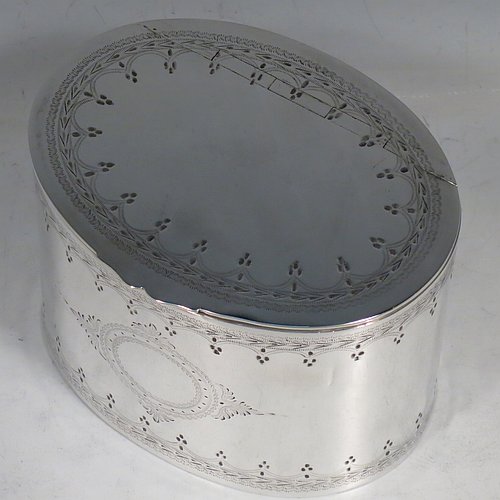 An Antique Victorian Silver Plated tea caddy box, having an oval straight-sided body, a flat lid with a hidden hinge, with hand-engraved bands of floral decoration top and bottom, together with two round  cartouches front and back, and sitting on a flat base. Made by the Mappin Brothers in ca. 1870. The dimensions of this fine hand-made antique silver-plated tea caddy box are height 9 cms (3.5 inches), length 12 cms (4.75 inches), and width 9 cms (3.5 inches).