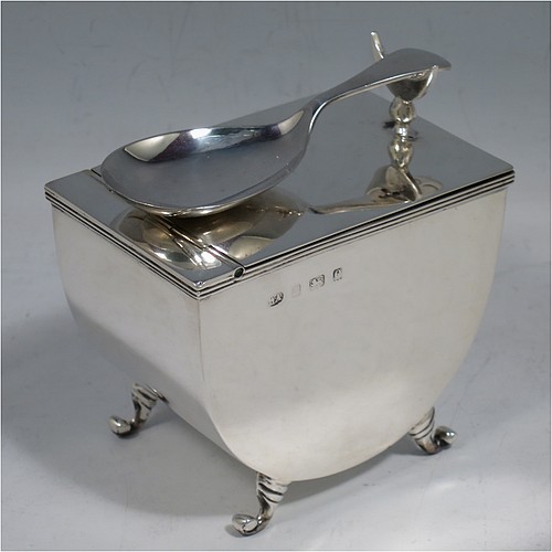 A very unusual Antique Edwardian Sterling Silver tea caddy box, having a plain U-shaped body with straight sides, a hinged lid with crescent shaped tea caddy spoon rest, a gold-gilt interior, and sitting on four cast scroll feet, together with a matching Old English pattern tea caddy spoon. Made by William Aitken of Birmingham in 1904 (the spoon made by Henry Atkins of Sheffield in 1918). The dimensions of this fine hand-made antique silver tea caddy box are height 7 cms (2.75 inches), length 9 cms (3.5 inches), width 6 cms (2.25 inches), and it weighs approx. 191g (6 troy ounces).