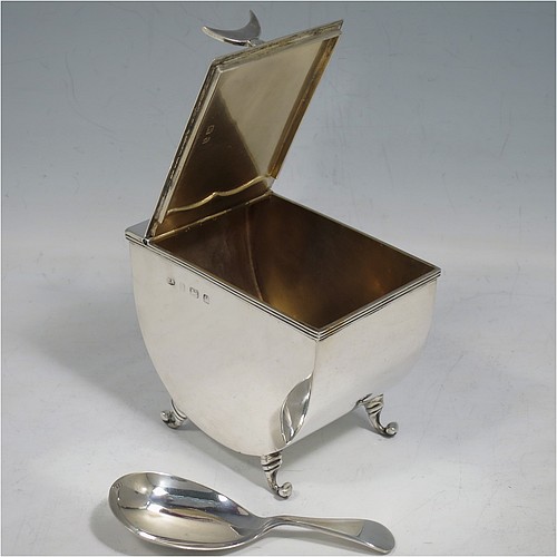 A very unusual Antique Edwardian Sterling Silver tea caddy box, having a plain U-shaped body with straight sides, a hinged lid with crescent shaped tea caddy spoon rest, a gold-gilt interior, and sitting on four cast scroll feet, together with a matching Old English pattern tea caddy spoon. Made by William Aitken of Birmingham in 1904 (the spoon made by Henry Atkins of Sheffield in 1918). The dimensions of this fine hand-made antique silver tea caddy box are height 7 cms (2.75 inches), length 9 cms (3.5 inches), width 6 cms (2.25 inches), and it weighs approx. 191g (6 troy ounces).