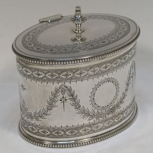 A very pretty Antique Victorian Sterling Silver tea caddy box, having an oval straight-sided body with applied bead borders, a cast urn-shaped finial sitting on a flat hinged lid, with hand-engraved bands top and bottom, together with neoclassical style engraved swags surrounding round vacant cartouches on either side, and all sitting on a flat base. This beautiful antique silver tea caddy box was made by Henry Wilkinson and Co., of London in 1875. The dimensions of this fine hand-made antique silver tea caddy box are height 11 cms (4.3 inches), length 13 cms (5 inches), depth 10 cms (4 inches), and it weighs approx. 407g (13 troy ounces).  