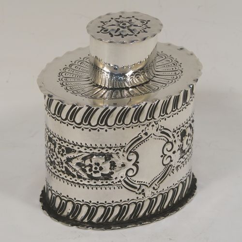 A very pretty Antique Victorian Sterling Silver tea caddy box, having an oval straight-sided body with hand-chased floral, scroll, and swirl-fluted decoration, with a vacant cartouche on both sides and with hand-crimped borders, a pull-off lid with matching decoration, and all sitting on a flat base. This beautiful antique silver tea caddy box was made by Jackson and Fullerton of London in 1899. The dimensions of this fine hand-made antique silver tea caddy box are height 9 cms (3.5 inches), length 8 cms (3.25 inches), width 6.5 cms (2.5 inches), and it weighs approx. 113g (3.6 troy ounces).  