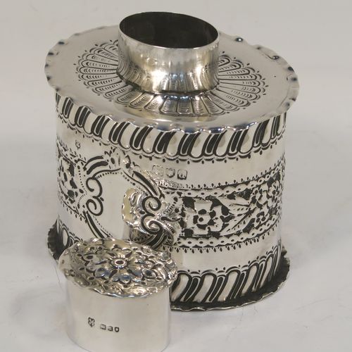 A very pretty Antique Victorian Sterling Silver tea caddy box, having an oval straight-sided body with hand-chased floral, scroll, and swirl-fluted decoration, with a vacant cartouche on both sides and with hand-crimped borders, a pull-off lid with matching decoration, and all sitting on a flat base. This beautiful antique silver tea caddy box was made by Jackson and Fullerton of London in 1899. The dimensions of this fine hand-made antique silver tea caddy box are height 9 cms (3.5 inches), length 8 cms (3.25 inches), width 6.5 cms (2.5 inches), and it weighs approx. 113g (3.6 troy ounces).  