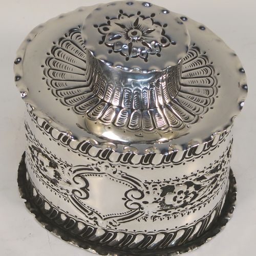 A very pretty Antique Victorian Sterling Silver tea caddy box, having an oval straight-sided body with hand-chased floral, scroll, and swirl-fluted decoration, with a vacant cartouche on both sides and with hand-crimped borders, a pull-off lid with matching decoration, and all sitting on a flat base. This beautiful antique silver tea caddy box was made by Jackson and Fullerton of London in 1899. The dimensions of this fine hand-made antique silver tea caddy box are height 9 cms (3.5 inches), length 8 cms (3.25 inches), width 6.5 cms (2.5 inches), and it weighs approx. 113g (3.6 troy ounces).  