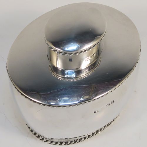 A very handsome Antique Sterling Silver tea caddy box, having an plain oval bellied body with applied gadroon borders, and a pull-off lid which was used as a measure, and all sitting on a flat base. This elegant silver tea caddy box was made by George Unite of Birmingham in 1924. The dimensions of this fine hand-made antique silver tea caddy box are height 8 cms (3.25 inches), length 8 cms (3.25 inches), width 6.5 cms (2.5 inches), and it weighs approx. 118g (3.8 troy ounces).   