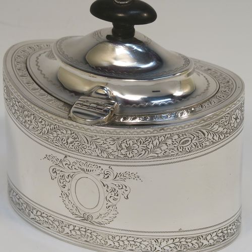 A very pretty Antique Edwardian Sterling Silver tea caddy box, having an oval straight-sided body, a wooden finial sitting on an oval domed and hinged lid, all with hand-engraved bands of floral decoration, together with floral engraving surrounding oval vacant cartouches on either side, and all sitting on a flat base. This beautiful antique silver tea caddy box was made by William Hutton and Sons of Sheffield in 1902. The dimensions of this fine hand-made antique silver tea caddy box are height 9.5 cms (3.75 inches), length 11 cms (4.25 inches), depth 7.5 cms (3 inches), and it weighs approx. 230g (7.4 troy ounces).   