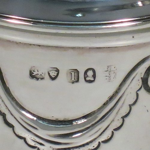 An Antique Georgian Sterling Silver tea caddy box, having a round straight-sided body with hand-chased Neoclassical style swags and anthemion leaves, with applied reeded borders, a pull-off domed lid with cast acorn finial, and all sitting on a flat base. Made by the Lias Brothers of London in 1826. The dimensions of this fine antique silver tea caddy box are height 12 cms (4.75 inches), diameter 7 cms (2.75 inches), and it weighs approx. 190g (6 troy ounces).    