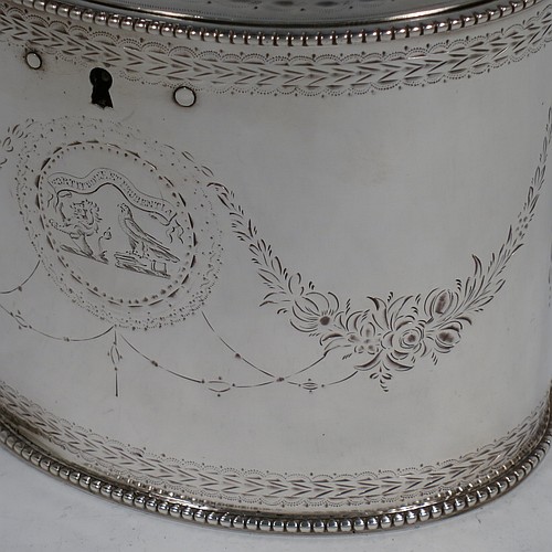 A very handsome Antique Georgian Sterling Silver tea caddy box, having an oval straight-sided body with applied bead borders, a cast floral finial sitting on a lid with flat hidden hinge, with hand-engraved bands top and bottom, together with neoclassical style engraved swags, and original lock with key. Made by Samuel Wood of London in 1779. The dimensions of this fine hand-made antique tea caddy box are height 10 cms (4 inches), length 12 cms (4.75 inches), width 9 cms (3.5 inches), and it weighs approx. 385g (12.4 troy ounces).