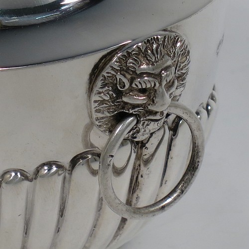 An Antique Edwardian Sterling Silver tea caddy box, having an oval bellied body with hand-chased half-fluted decoration, two lion-mask and ring side-handles, a hinged domed lid with matching fluting and a cast urn finial, and all sitting on a collet foot. Made by Goldsmiths and Silversmiths of London in 1906. The dimensions of this fine hand-made antique silver tea caddy box are height 11 cms (4.25 inches), length 12.5 cms (5 inches), width 8 cms (3.25 inches), and it weighs approx. 198g (6.4 troy ounces).   