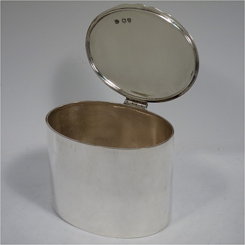 A very stylish Antique Victorian Sterling Silver tea caddy box, having a very plain oval body with straight sides, a flat hinged plain lid with shaped thumb-piece, and sitting on a flat base. Made by William Hutton of London in 1893. The dimensions of this fine hand-made antique silver tea caddy box are height 8 cms (3 inches), length 10 cms (4 inches), depth 8 cms (3 inches), and it weighs approx. 185g (6 troy ounces).    