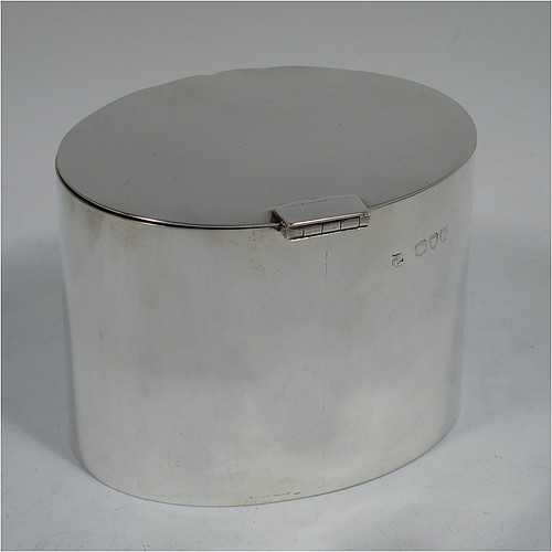 A very stylish Antique Victorian Sterling Silver tea caddy box, having a very plain oval body with straight sides, a flat hinged plain lid with shaped thumb-piece, and sitting on a flat base. Made by William Hutton of London in 1893. The dimensions of this fine hand-made antique silver tea caddy box are height 8 cms (3 inches), length 10 cms (4 inches), depth 8 cms (3 inches), and it weighs approx. 185g (6 troy ounces).    