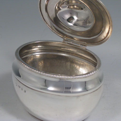 An Antique Georgian Sterling Silver tea caddy box, having a plain oval bellied body with a hand-chased reeded upper band and gadroon border, a hinged domed lid with a cast ball finial, and all sitting on a flat base. Made by John Watson of Sheffield in 1813. The dimensions of this fine hand-made antique silver tea caddy box are height 12 cms (4.75 inches), length 11.5 cms (4.5 inches), width 9 cms (3.5 inches), and it weighs approx. 217g (7 troy ounces).