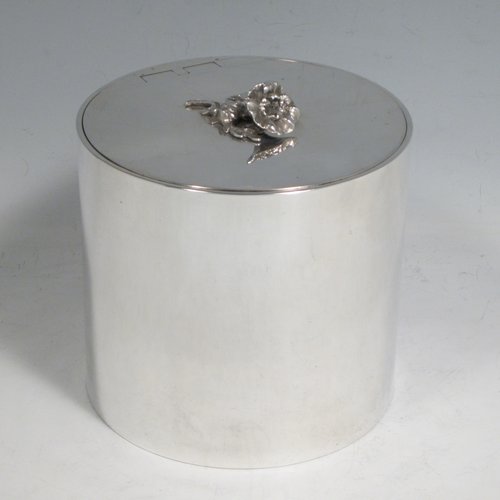 Sterling silver tea caddy box in a Georgian style, having a plain cylindrical body with straight sides, an invisibly hinged flat lid with floral finial, and sitting on a flat base. Made by Alston & Halom of London in 1918. The dimensions of this fine hand-made silver tea caddy box are height 10 cms (4 inches), diameter 11 cms (4.25 inches), and it weighs approx. 437g (14 troy ounces).   