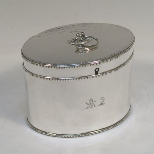 A very handsome Antique Georgian Sterling Silver tea caddy box, having an oval straight-sided body with applied bead borders, a loop handle finial attached to a lid with flat hidden hinge and bright-cut engraved decoration, and original lock but no key. This elegant antique silver tea caddy box was made by Younge, Greaves, and Hoyland of Sheffield in 1785. The dimensions of this fine hand-made antique tea caddy box are height 9 cms (3.5 inches), length 12.5 cms (5 inches), width 9 cms (3.5 inches), and it weighs approx. 328g (10.5 troy ounces). Please note that this item is crested.