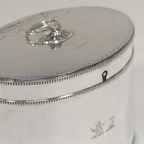 A very handsome Antique Georgian Sterling Silver tea caddy box, having an oval straight-sided body with applied bead borders, a loop handle finial attached to a lid with flat hidden hinge and bright-cut engraved decoration, and original lock but no key. This elegant antique silver tea caddy box was made by Younge, Greaves, and Hoyland of Sheffield in 1785. The dimensions of this fine hand-made antique tea caddy box are height 9 cms (3.5 inches), length 12.5 cms (5 inches), width 9 cms (3.5 inches), and it weighs approx. 328g (10.5 troy ounces). Please note that this item is crested.