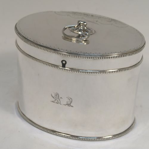 A very handsome Antique Georgian Sterling Silver tea caddy box, having an oval straight-sided body with applied bead borders, a loop handle finial attached to a lid with flat hidden hinge and bright-cut engraved decoration, and original lock but no key. This elegant antique silver tea caddy box was made by Younge, Greaves, and Hoyland of Sheffield in 1785. The dimensions of this fine hand-made antique tea caddy box are height 9 cms (3.5 inches), length 12.5 cms (5 inches), width 9 cms (3.5 inches), and it weighs approx. 328g (10.5 troy ounces). Please note that this item is crested.