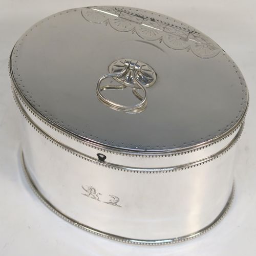 A very handsome Antique Georgian Sterling Silver tea caddy box, having an oval straight-sided body with applied bead borders, a loop handle finial attached to a lid with flat hidden hinge and bright-cut engraved decoration, and original lock but no key. This elegant antique silver tea caddy box was made by Younge, Greaves, and Hoyland of Sheffield in 1785. The dimensions of this fine hand-made antique tea caddy box are height 9 cms (3.5 inches), length 12.5 cms (5 inches), width 9 cms (3.5 inches), and it weighs approx. 328g (10.5 troy ounces). Please note that this item is crested.