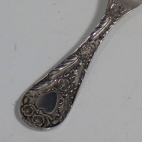 An Antique Edwardian Sterling Silver tea caddy spoon, having a hand-chased handle with floral decoration, a heart-shaped vacant cartouche, and a hand-chased fluted oval bowl. Made by Montague Friedlander of Chester in 1906. The dimensions of this fine hand-made antique silver tea caddy spoon are length 9.5 cms (3.75 inches), width across bowl 4 cms (1.5 inches), and it weighs approx. 16g (0.5 troy ounces).