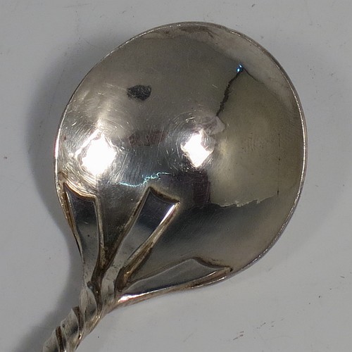 An Arts and Crafts Sterling Silver tea caddy spoon, having a cast twisted ribbon style handle with two applied beads between the turned-over ribbon ends, and a plenished hand-hammered round bowl. Made by Leonard William Burt of London in 1957. The dimensions of this fine hand-made Arts and Crafts style silver tea caddy spoon are length 9 cms (3.5 inches), width across bowl 4 cms (1.5 inches), and it weighs approx. 24g (0.75 troy ounces).