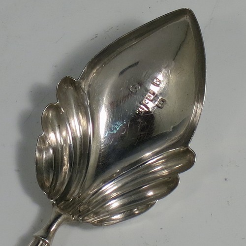 An Antique Georgian Sterling Silver tea caddy spoon, having a hand-chased handle with reeded anthemion leaf floral decoration, and a hand-chased fluted oval pointed bowl. Made by Thomas Fowke of London in 1831. The dimensions of this fine hand-made antique silver tea caddy spoon are length 10 cms (4 inches), width across bowl 3.5 cms (1.3 inches), and it weighs approx. 8g (0.25 troy ounces).