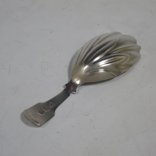 An Antique Georgian Sterling Silver tea caddy spoon, having a plain Fiddle pattern handle, and a hand-chased fluted oval bowl. Made by Francis Parsons of Exeter in 1819. The dimensions of this fine hand-made antique silver tea caddy spoon are length 9 cms (3.5 inches), width across bowl 3 cms (1.25 inches), and it weighs approx. 10g (0.3 troy ounces).   