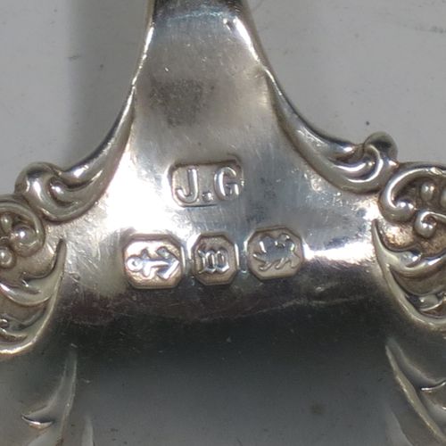 An Antique Sterling Silver tea caddy spoon, with a floral patterned handle, and a hand-chased oval bowl with scroll decoration. Made by Joseph Gloster of Birmingham in 1911. The dimensions of this fine hand-made antique silver tea caddy spoon are length 10 cms (4 inches), width across bowl 3.5 cms (1.3 inches), and it weighs approx. 18g (0.6 troy ounces).    