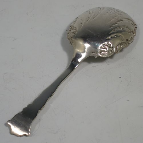 An Antique Sterling Silver tea caddy spoon, with a floral patterned handle, and a hand-chased oval bowl with scroll decoration. Made by Joseph Gloster of Birmingham in 1911. The dimensions of this fine hand-made antique silver tea caddy spoon are length 10 cms (4 inches), width across bowl 3.5 cms (1.3 inches), and it weighs approx. 18g (0.6 troy ounces).    