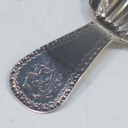 A very elegant Antique Georgian Sterling Silver tea caddy spoon, having an engraved curved handle, and a hand-chased shell style round bowl. Made in London in 1785, with the rare Incuse Duty Mark. The dimensions of this fine hand-made antique silver tea caddy spoon are length 7 cms (2.75 inches), width 4 cms (1.5 inches), and it weighs approx. 9g (0.3 troy ounces). Please note that this item is monogrammed.