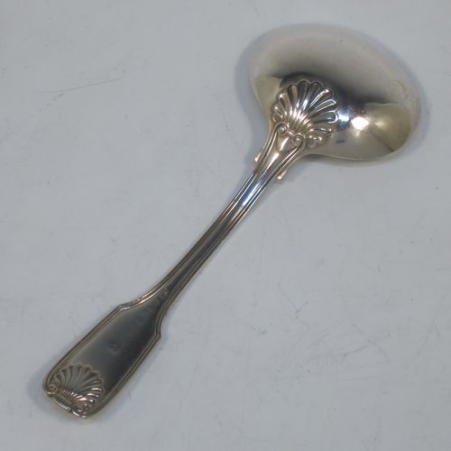 An Antique Georgian Sterling Silver tea caddy spoon, having a double-struck Fiddle, Thread, and Shell pattern handle, and a hand-engraved oval bowl with wriggle-work decoration. Made in ca. 1820 (marks rubbed). The dimensions of this fine hand-made antique silver tea caddy spoon are length 12 cms (4.75 inches), width across bowl 4.5 cms (1.75 inches), and it weighs approx. 27g (0.9 troy ounces).  