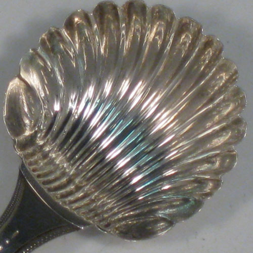 Antique Georgian sterling silver tea caddy spoon, having an engraved curved handle, and a hand-chased shell style bowl. Made by Peter, Anne, and William Bateman of London in 1800. The dimensions of this fine hand-made silver tea caddy spoon are length 8 cms (3 inches), width 4 cms (1.5 inches), and it weighs approx. 10g (0.3 troy ounces).