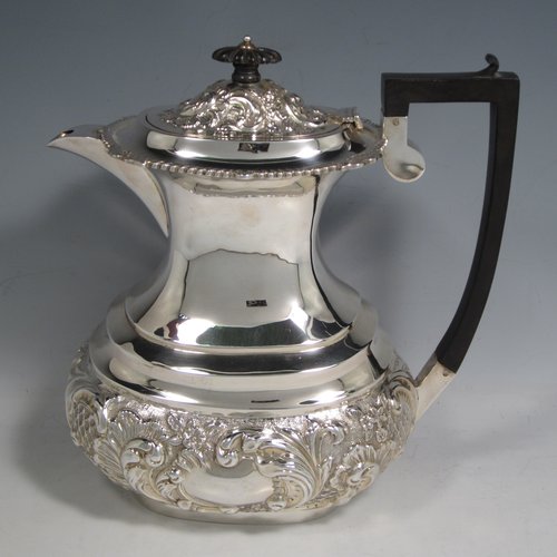 Antique Edwardian sterling silver four-piece tea and coffee set, having rectangular baluster bodies with rounded corners, with hand-chased floral decoration, and wooden handles and finials, the sugar bowl and cream jug with gold-gilt interiors, and all sitting on flat bases. Made by W. G. Knight of Birmingham in 1909. The dimensions of this fine hand-made silver tea and coffee service are length of teapot 32 cms (12.5 inches), height of hot-water pot 23 cms (9 inches), and the total weight is approx. 1,640g (53 troy ounces).   