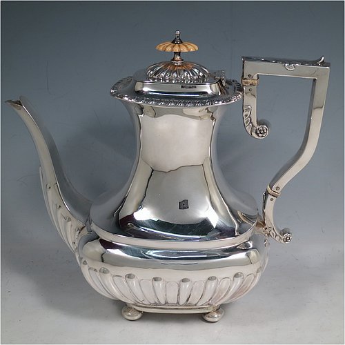 An Antique Edwardian Sterling Silver four-piece tea and coffee set in a Regency style, having rectangular baluster bodies, with hand-chased half-fluted decoration and applied gadroon borders, with insulated silver handles and bone finials, all sitting on four round cushion feet. Made by William Aitken of Birmingham in 1908. The dimensions of this fine hand-made silver tea and coffee service are length of teapot 26 cms (10.25 inches), height of coffee pot 23 cms (9 inches), and the total weight is approx. 1,760g (56.8 troy ounces).    