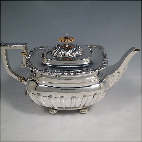 An Antique Edwardian Sterling Silver four-piece tea and coffee set in a Regency style, having rectangular baluster bodies, with hand-chased half-fluted decoration and applied gadroon borders, with insulated silver handles and bone finials, all sitting on four round cushion feet. Made by William Aitken of Birmingham in 1908. The dimensions of this fine hand-made silver tea and coffee service are length of teapot 26 cms (10.25 inches), height of coffee pot 23 cms (9 inches), and the total weight is approx. 1,760g (56.8 troy ounces).    