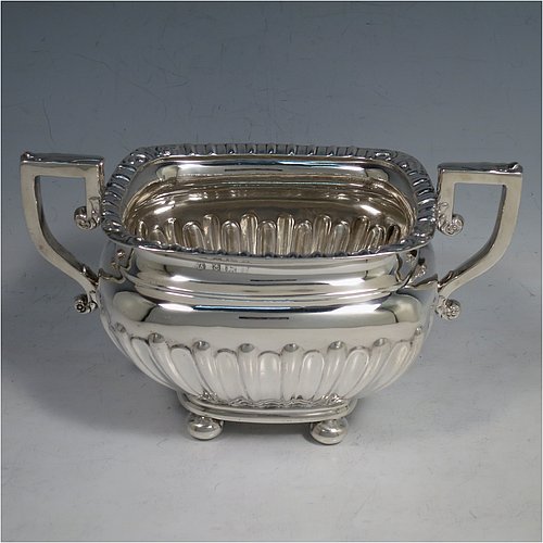 An Antique Edwardian Sterling Silver four-piece tea and coffee set in a Regency style, having rectangular baluster bodies, with hand-chased half-fluted decoration and applied gadroon borders, with insulated silver handles and bone finials, all sitting on four round cushion feet. Made by William Aitken of Birmingham in 1908. The dimensions of this fine hand-made silver tea and coffee service are length of teapot 26 cms (10.25 inches), height of coffee pot 23 cms (9 inches), and the total weight is approx. 1,760g (56.8 troy ounces).    