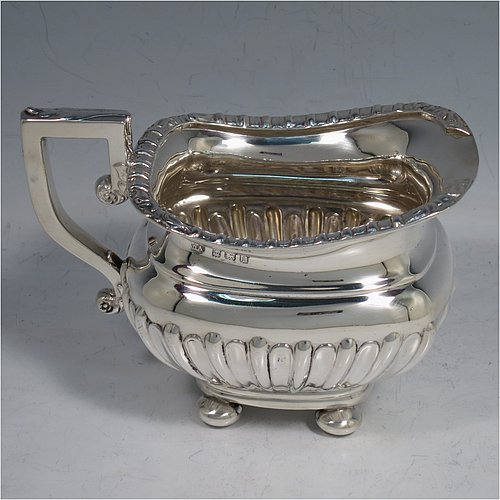 An Antique Edwardian Sterling Silver four-piece tea and coffee set in a Regency style, having rectangular baluster bodies, with hand-chased half-fluted decoration and applied gadroon borders, with insulated silver handles and bone finials, all sitting on four round cushion feet. Made by William Aitken of Birmingham in 1908. The dimensions of this fine hand-made silver tea and coffee service are length of teapot 26 cms (10.25 inches), height of coffee pot 23 cms (9 inches), and the total weight is approx. 1,760g (56.8 troy ounces).    