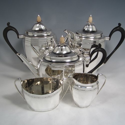 Sterling silver Georgian style five-piece tea and coffee service, consisting of teapot, coffee pot, hot water pot, sugar bowl and cream jug. Having oval panelled bodies with a band of floral decoration, with wooden handles and ivory pineapple shaped finials, and sitting on flat bases. Made by Roberts & Belk of Sheffield in 1919. The dimensions of this fine hand-made tea and coffee service are length of teapot 27 cms (10.5 inches), height of coffee pot 22 cms (8.75 inches), and the total weight is approx. 1,800g (58 troy ounces).