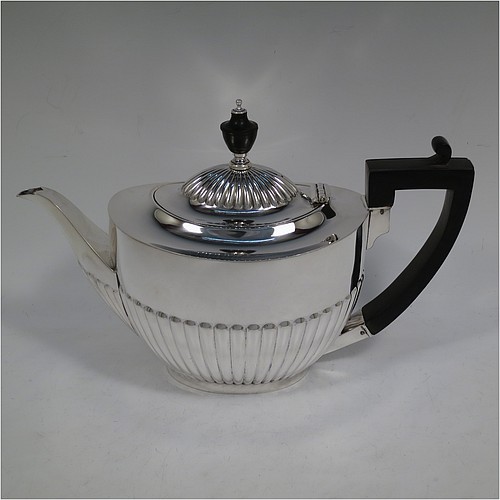 A very handsome Antique Edwardian Sterling Silver Queen Anne style four-piece tea and coffee set consisting of a coffee pot, tea-pot, sugar bowl, and milk / cream jug, having oval bodies with hand-chased half-fluted decoration, with wooden handles and finials, and all sitting on pedestal and collet feet. All made by Roberts and Belk of Sheffield in 1907/10. The dimensions of this fine hand-made antique silver tea and coffee service are length of teapot 26.5 cms (10.5 inches), height of coffee pot 26 cms (10.25 inches), and the total weight is approx. 1,350g (42 troy ounces).   