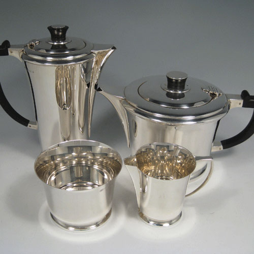 Sterling silver Art Deco style four-piece tea and coffee service, having plain round tapering bodies, with wooden handles and finials, and sitting on collet feet. Made by Hukin & Heath of Birmingham in 1938. The dimensions of this fine hand-made tea snd coffee service are length of teapot 23 cms (9 inches), height of coffee pot 20 cms (8 inches), and the total weight is approx. 1,426g (46 troy ounces).