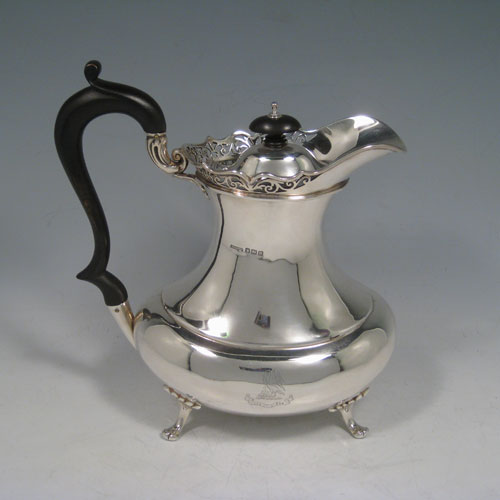 Antique Edwardian sterling silver tea and coffee service set, having plain oval baluster bodies, applied hand-pierced gallery top borders, black wooden handles and finials, and all sitting on four cast foliate feet. This set consists of a hot-water kettle on burner stand, a teapot, coffee pot, sugar bowl, and cream jug. All made by T.E. Co., Ltd., of Sheffield in 1904. The dimensions of this fine hand-made tea and coffee set are height (of kettle) 30.5 cms (12 inches), length (of teapot)30.5 cms (12 inches), and it weighs a total of approx. 2,850 (92 troy ounces). Please note that this service is crested.