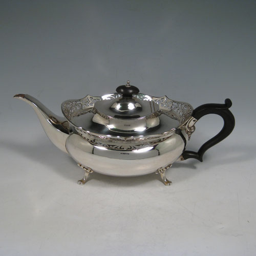 Antique Edwardian sterling silver tea and coffee service set, having plain oval baluster bodies, applied hand-pierced gallery top borders, black wooden handles and finials, and all sitting on four cast foliate feet. This set consists of a hot-water kettle on burner stand, a teapot, coffee pot, sugar bowl, and cream jug. All made by T.E. Co., Ltd., of Sheffield in 1904. The dimensions of this fine hand-made tea and coffee set are height (of kettle) 30.5 cms (12 inches), length (of teapot)30.5 cms (12 inches), and it weighs a total of approx. 2,850 (92 troy ounces). Please note that this service is crested.