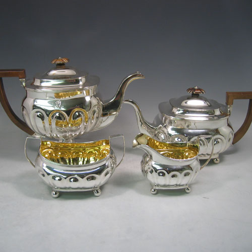 Antique Georgian sterling silver four-piece tea and coffee service, consisting of a coffee pot, tea pot, sugar bowl, and cream jug, having melon fluted bodies, gold gilt interiors, hinged lids with wooden finials, and insulated wooden handles, all sitting on four ball feet. Made by Henry Nutting and Robert Hennell II of London in 1808. Height of coffee pot 21.5 cms (8.5 inches), length of teapot 27 cms (10.5 inches). Total weight approx. 1,800g (58 troy ounces). Please note that all items are part-crested.