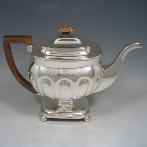 Antique Georgian sterling silver four-piece tea and coffee service, consisting of a coffee pot, tea pot, sugar bowl, and cream jug, having melon fluted bodies, gold gilt interiors, hinged lids with wooden finials, and insulated wooden handles, all sitting on four ball feet. Made by Henry Nutting and Robert Hennell II of London in 1808. Height of coffee pot 21.5 cms (8.5 inches), length of teapot 27 cms (10.5 inches). Total weight approx. 1,800g (58 troy ounces). Please note that all items are part-crested.