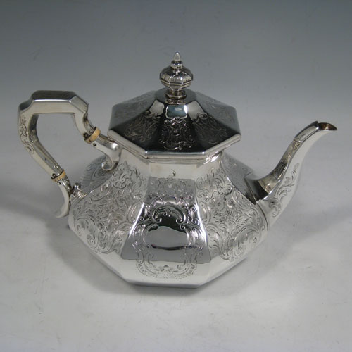 A very pretty Antique Victorian Sterling Silver four-piece tea and coffee service, consisting of a coffee pot, tea pot, sugar bowl, and cream jug, having octagonal panelled bodies with hand-engraved floral and scroll decoration, hinged lids with finials, and insulated silver handles. This beautiful antique silver tea and coffee set was made by William Kerr Reid of London in 1850. The dimensions of this fine hand-made silver service are height of coffee pot 25 cms (10 inches), length of teapot 23.5 cms (9.25 inches), and with a total weight approx. 1,740g (56 troy ounces).