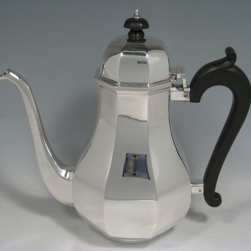    Sterling silver tea and coffee service, consisting of a coffee pot, teapot, sugar bow, and cream jug, having panelled bodies, wooden handles and finials, and hinged domed lids. Made by Garrards of London in 1957. Height of coffee pot 22 cms (8.75 inches), length of teapot 26 cms (10.75 inches). Total weight approx. 2,350g (75.8 troy ounces).