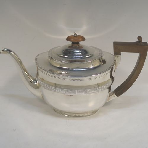 A very elegant Sterling Silver Georgian style four-piece tea and coffee service, consisting of a teapot, hot water or coffee pot, sugar bowl and cream jug. Having plain oval bodies with bands of  hand-engraved Greek-Key decoration, the teapot and water pot with wooden handles and finials, the cream jug and sugar bowl with applied reeded borders, and all sitting on collet feet. This handsome silver tea and coffee service was made by James Dixon and Sons of Sheffield in 1939. The dimensions of this fine hand-made tea and coffee set are length of teapot 27.5 cms (10.75 inches), height of coffee pot 18.5 cms (7.25 inches), and the total weight is approx. 1,300g (42 troy ounces).  