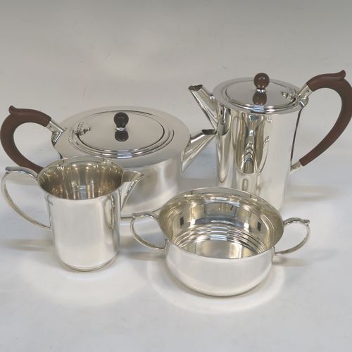 A very handsome and stylish Sterling Silver Art Deco style four-piece tea and coffee service, having very plain round bodies, with brown stained wooden handles and finials, and all sitting on flat stepped bases. This very elegant silver tea and coffee service was made by Alvic Products Ltd., of Birmingham in 1947. The dimensions of this fine hand-made Art Deco style tea and coffee set are length of teapot 23 cms (9 inches), height of coffee pot 15 cms (6 inches), and the total weight is approx. 1,127g (36 troy ounces).  