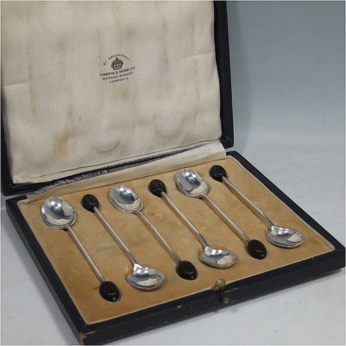 A Sterling Silver set of six tea or coffee spoons, having plain oval bowls, and handles with black coffee bean ends, all in their original cream satin and velvet-lined presentation box. Made by Mappin & Webb of Sheffield in 1925. The dimensions of this fine hand-made set of teaspoons or coffee spoons are length of each spoon 10 cms (4 inches), and the total weight is approx. 50g (1.5 troy ounces). Please note that the satin band covering the internal hinge is damaged.    