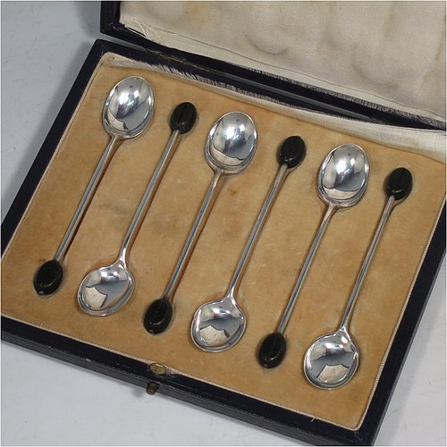 A Sterling Silver set of six tea or coffee spoons, having plain oval bowls, and handles with black coffee bean ends, all in their original cream satin and velvet-lined presentation box. Made by Mappin & Webb of Sheffield in 1925. The dimensions of this fine hand-made set of teaspoons or coffee spoons are length of each spoon 10 cms (4 inches), and the total weight is approx. 50g (1.5 troy ounces). Please note that the satin band covering the internal hinge is damaged.    