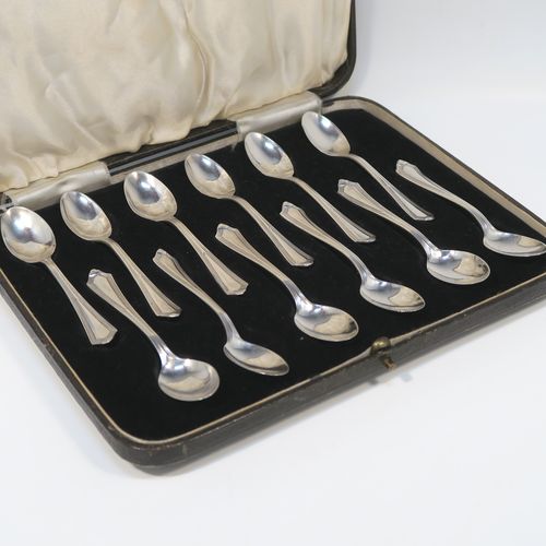 An elegant Art Deco style Sterling Silver set of twelve teaspoons or coffee spoons, having plain oval bowls, and handles with a single-struck reeded Pembury style pattern, all in their original cream satin and black velvet-lined presentation box. These pretty silver spoons were made by the Barker Brothers of Sheffield in 1936. The dimensions of this fine hand-made Art Deco set of sterling silver coffee spoons or teaspoons are length of each spoon 11 cms (4.3 inches), and the total weight is approx. 132g (4.3 troy ounce).   