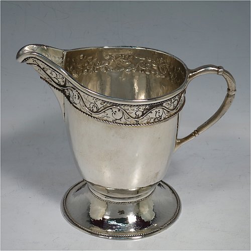 A unique Sterling Silver Arts and Crafts style three-piece tea set, having round bodies with hand-hammered decoration, with applied and hand-chased bands of floral work, the teapot with brown-stained wooden handle and finial, and the sugar and creamer with cast rounded handles, all with applied rope-twist borders, and all sitting on spreading pedestal feet. This beautiful silver tea set was made by Harold Edwin Landon of Chester in 1933. The dimensions of this fine hand-made Arts and Crafts tea service are height of teapot 18 cms (7 inches), length 28 cms (11 inches), diameter 15 cms (6 inches), and with a total weight of approx. 992g (32 troy ounces).